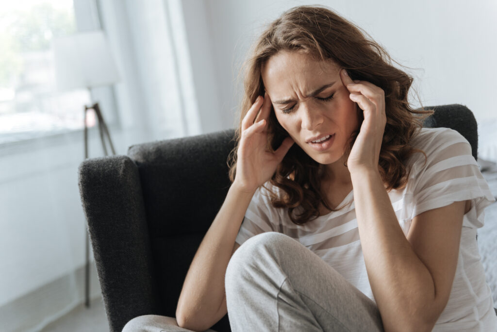 Unhappy cheerless woman having migraine