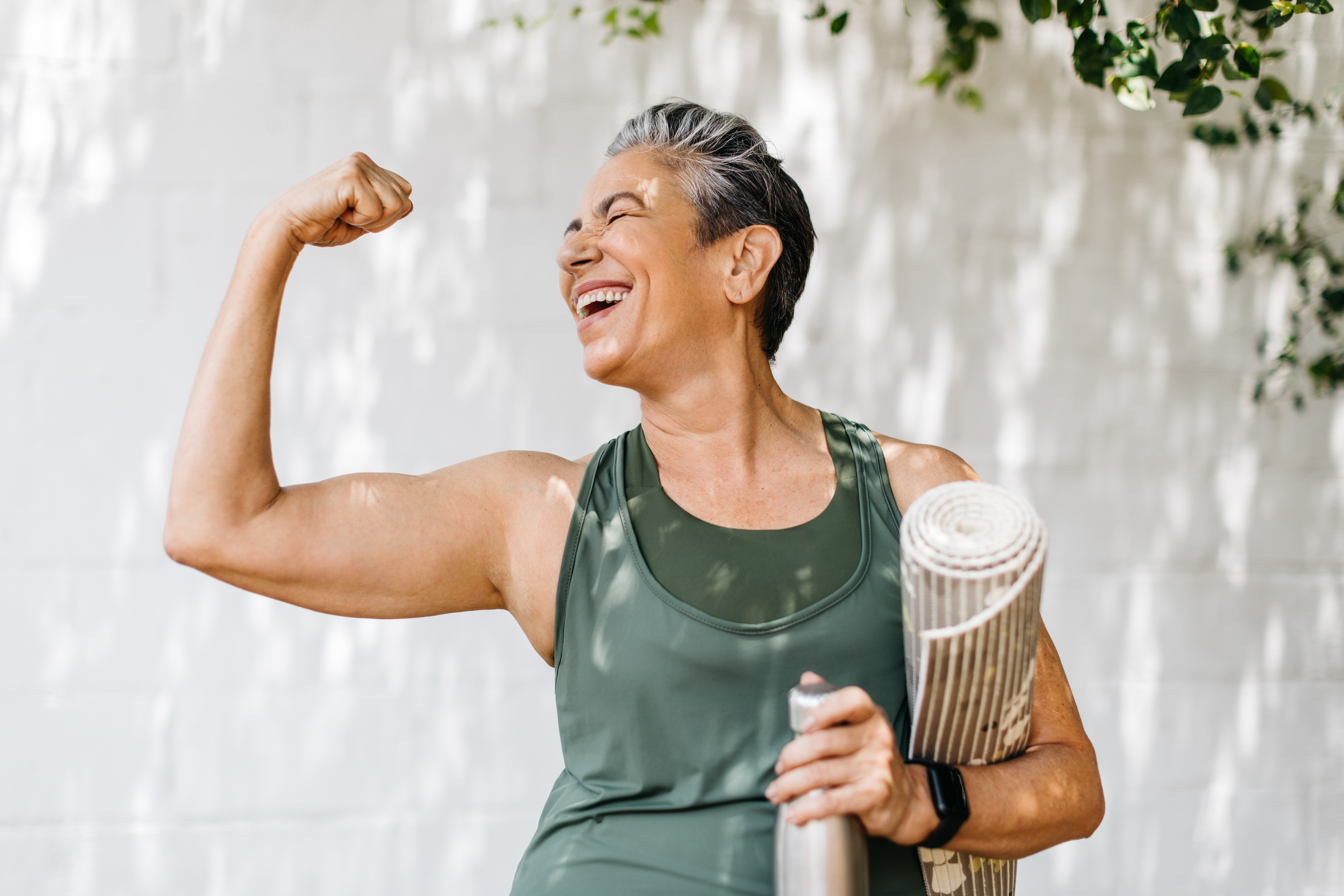 Woman celebrates her fitness achievements by flaunting her bicep outdoors